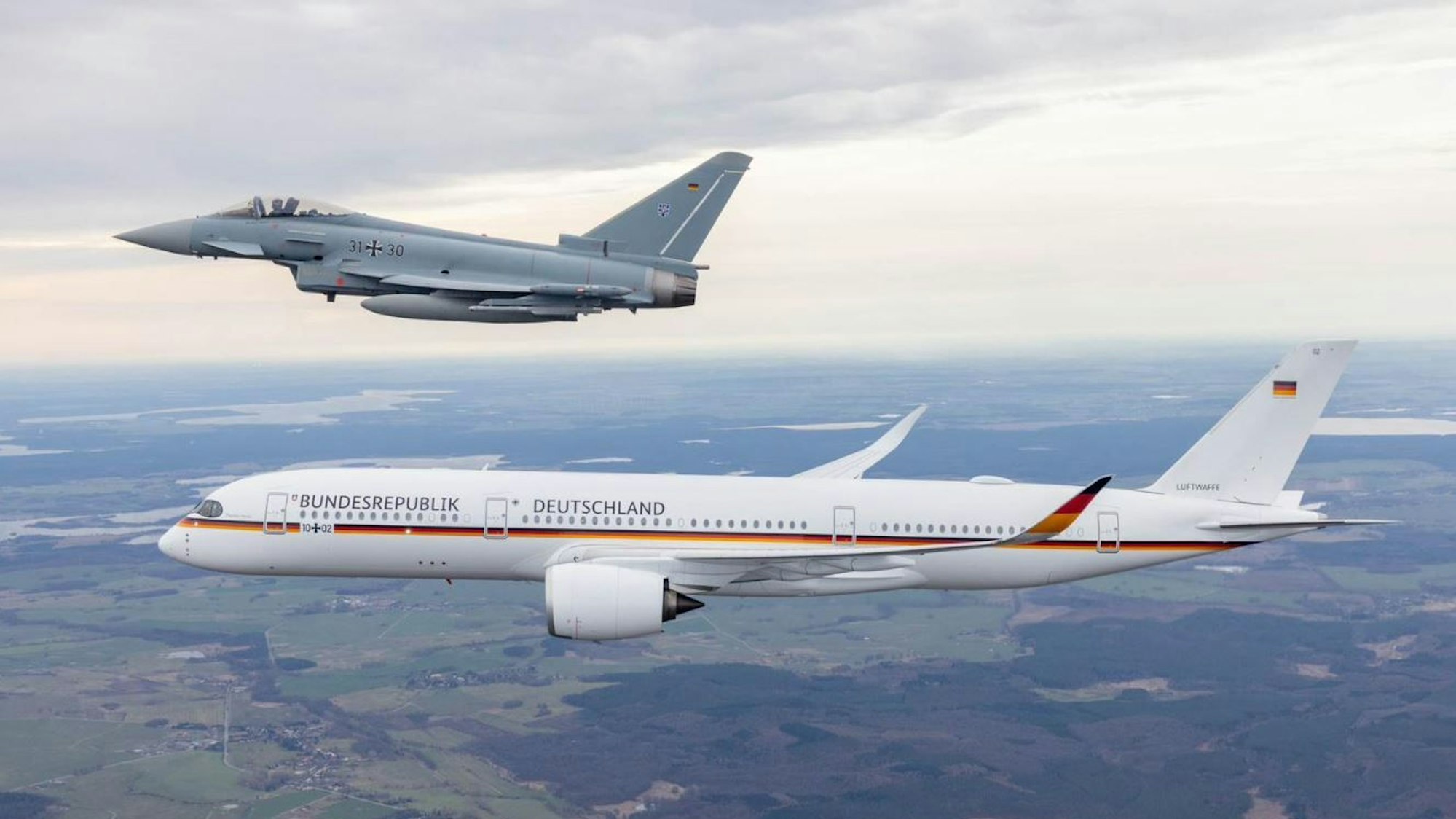 Ein Eurofighter der Luftwaffe fliegt neben dem Airbus A350 „Theodor Heuss“.