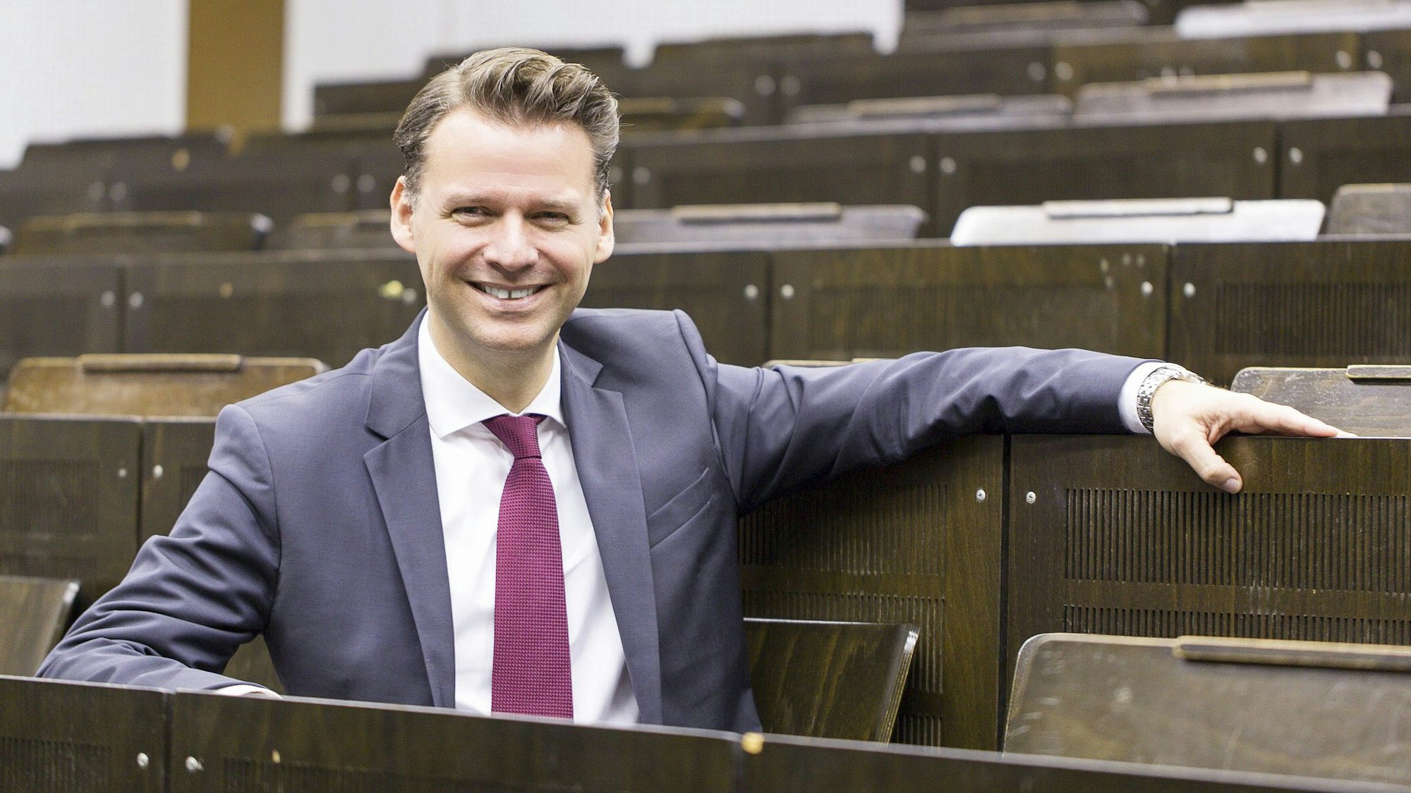 Der Wirtschaftswissenschafter Tobias Kollmann sitzt in einem Hörsaal.