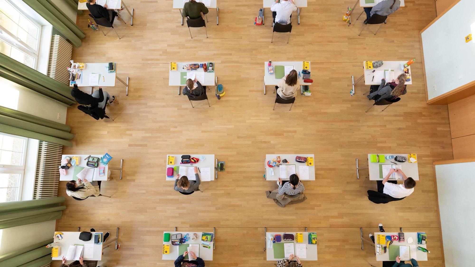 Schüler sitzen während der Abiturprüfung in einer Aula
