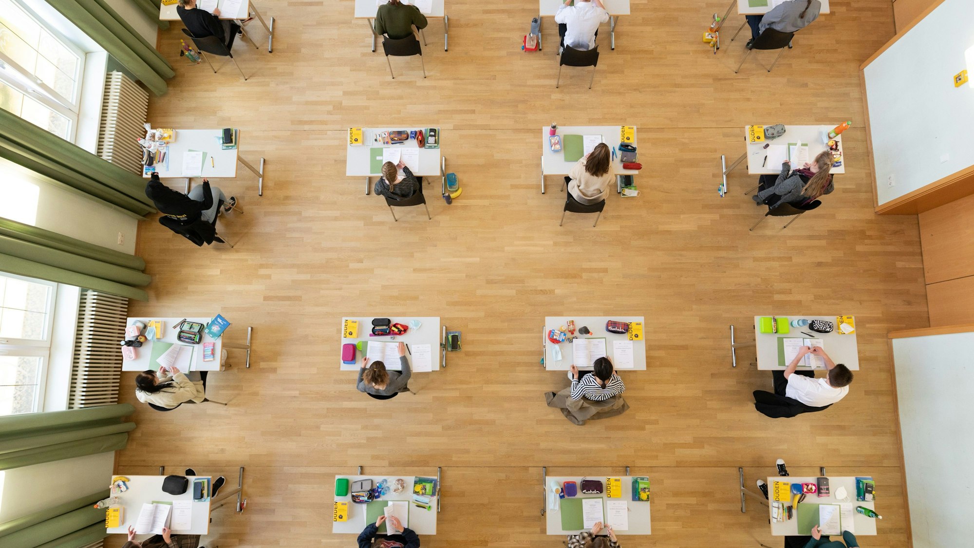Schüler sitzen während der Abiturprüfung in einer Aula