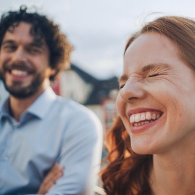 Eine Frau und ein Mann lachen und sehen glücklich aus
