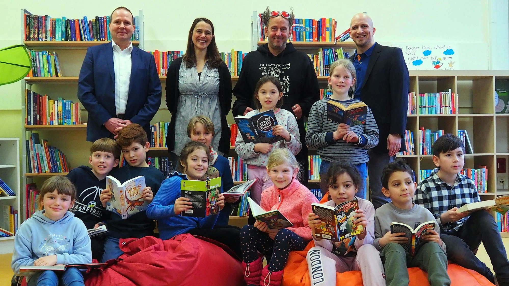 Grundschüler der Rosenzweiggrundschule in Zollstock sitzen auf bunten Sitzsäcken und halten Bücher in der Hand.