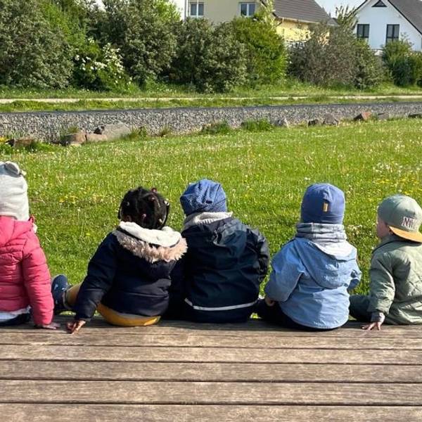 Das Bild zeigt mehrere Kinder in einem Garten.