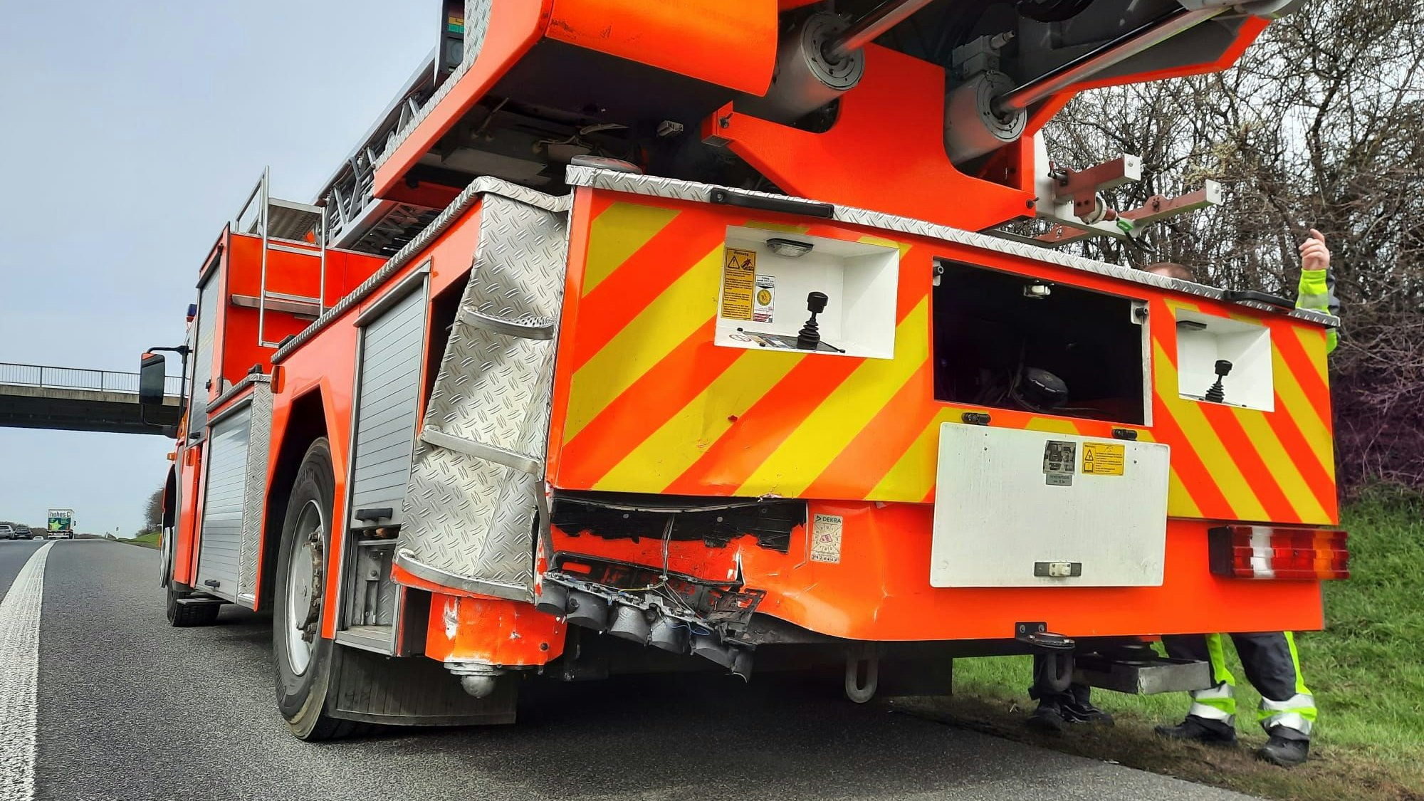 Eine rote Drehleiter der Feuerwehr steht auf dem Seitenstreifen der Autobahn.