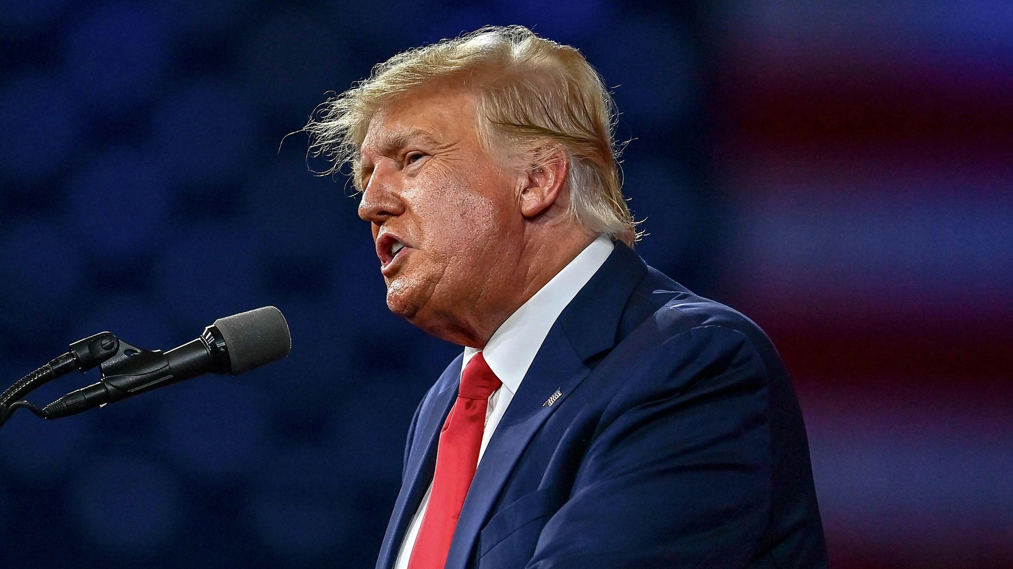 Donald Trump im Profil spricht in ein Mikro.