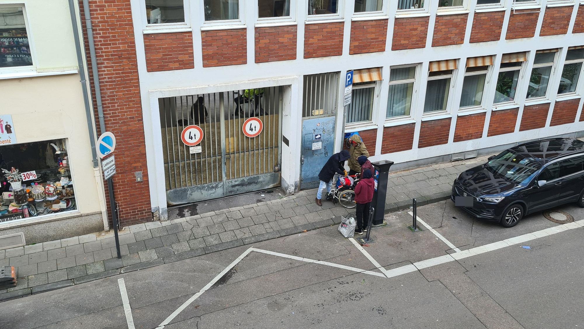 Drogenabhängige Menschen warten vor der verschlossenen Tür zum Drogenkonsumraum am Kölner Neumarkt.