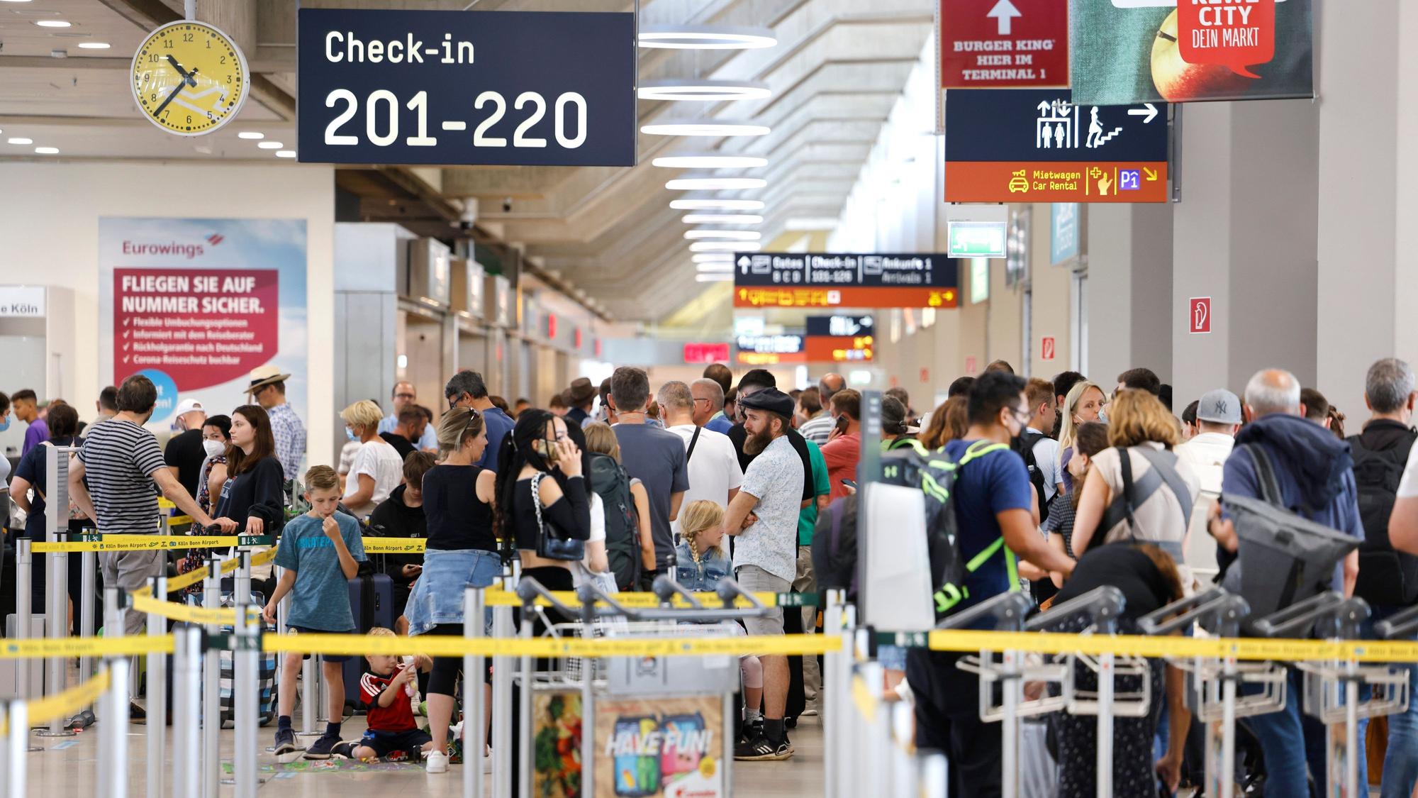 25.06.2022, Nordrhein-Westfalen, Köln: Passagiere stehen am Samstag Vormittag in einer Schlange von mehreren hundert Metern für die Sicherheitskontrolle am Flughafen Köln Bonn an.