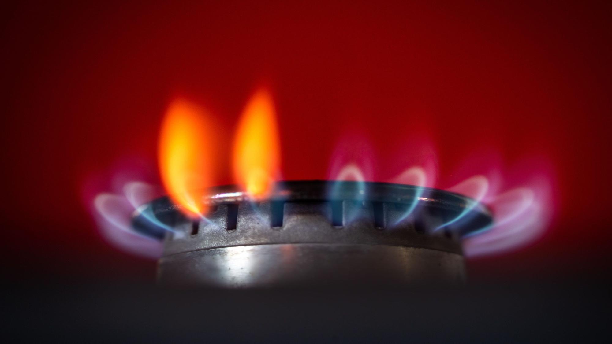 Die Flamme eines Gasherdes brennt in einer Küche.
