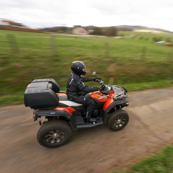Ein Quadfahrer ist auf einer Landstrasse unterwegs.