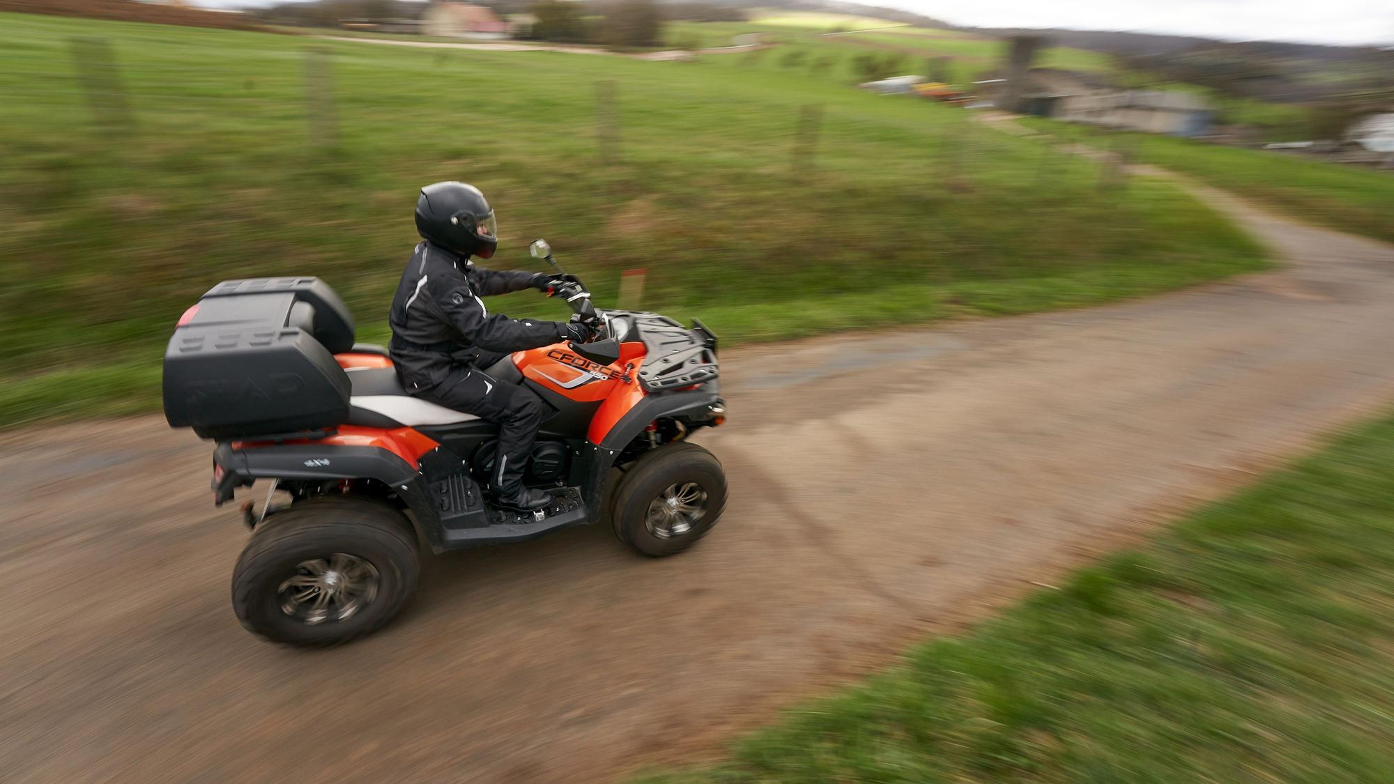 Ein Quadfahrer ist auf einer Landstrasse unterwegs.