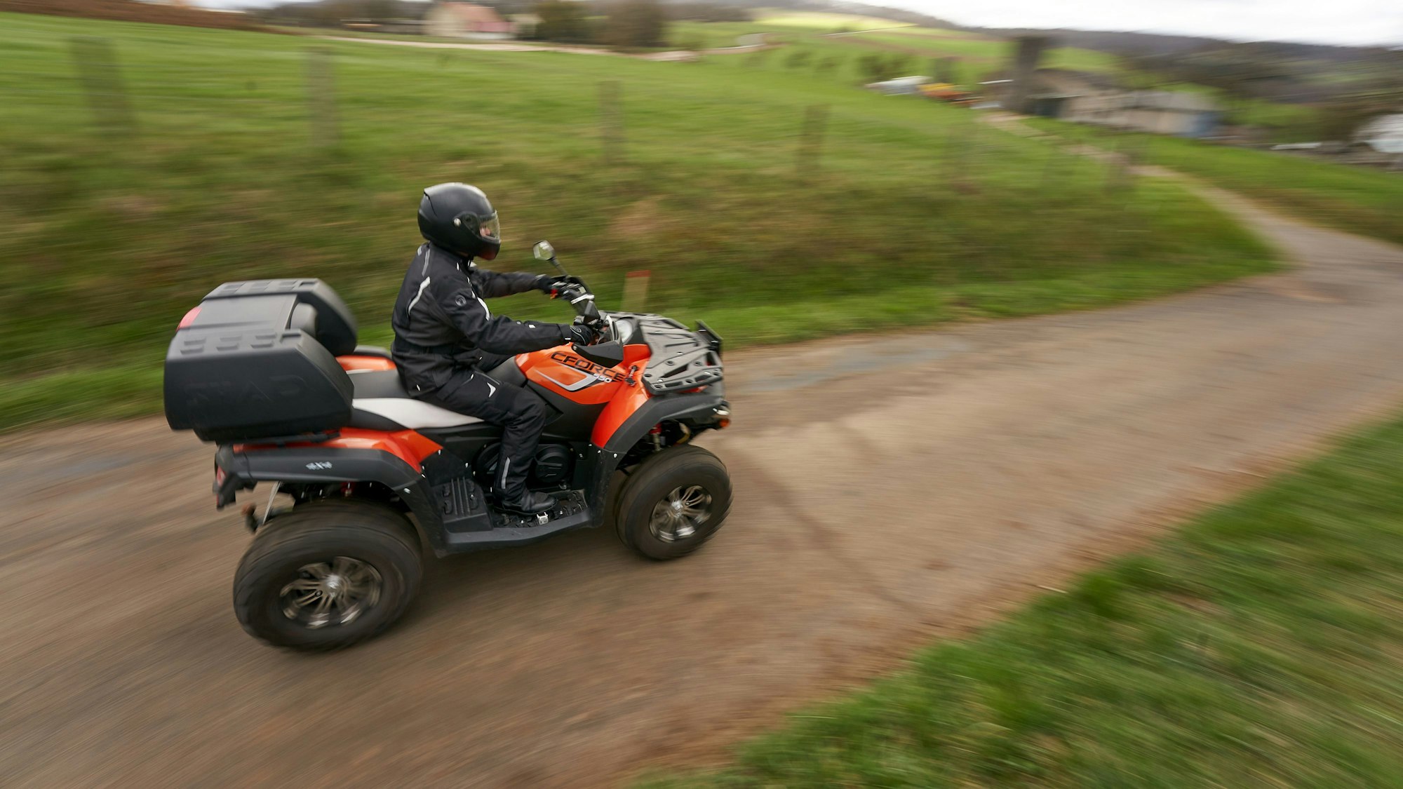 Ein Quadfahrer ist auf einer Landstrasse unterwegs.
