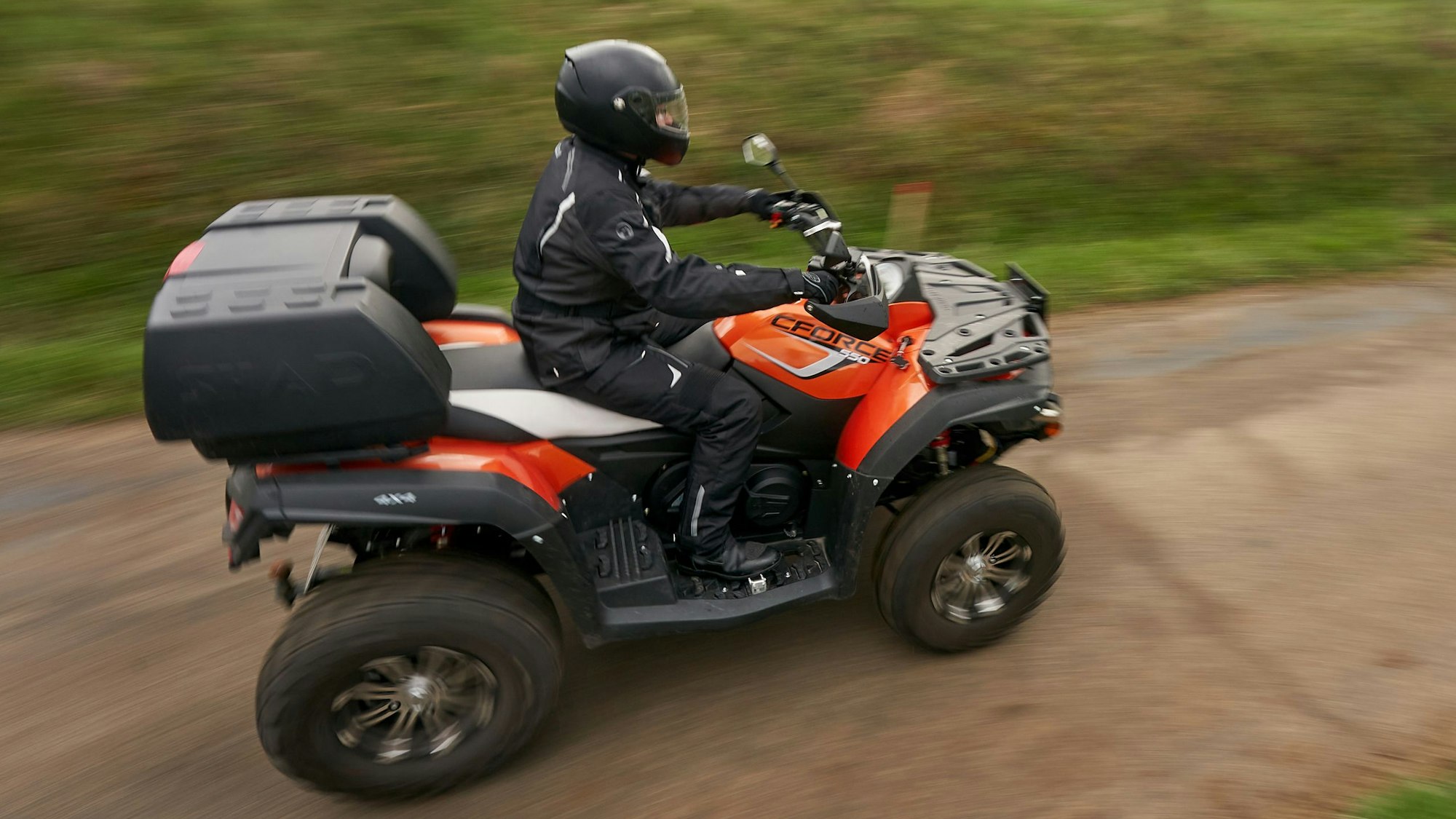 Ein Quadfahrer ist auf einer Landstraße unterwegs.