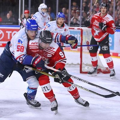 Tyler Gaudet von Adler Mannheim kämpft gegen Kölns Maximilian Kammerer um den Puck.