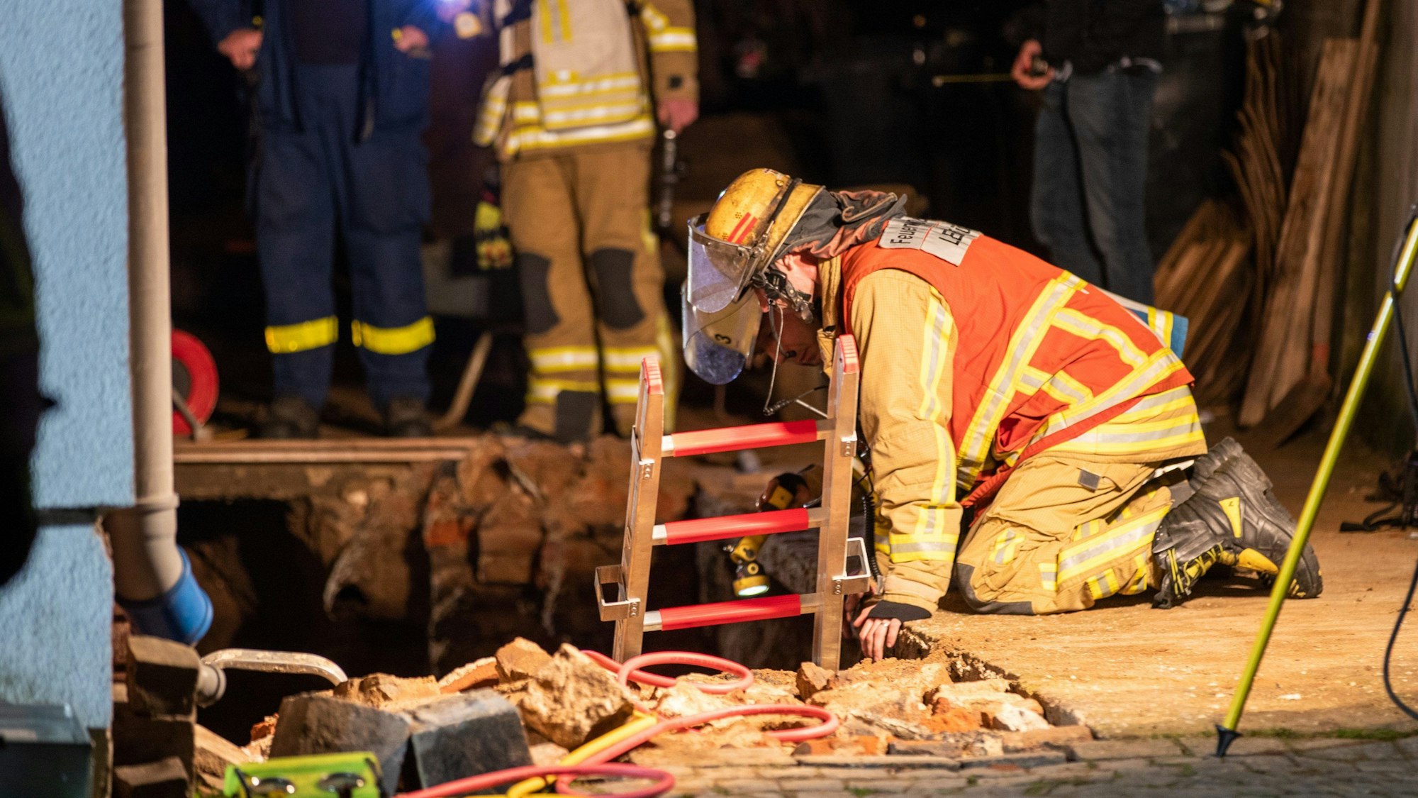 Duisburg: Rettungskräfte der Feuerwehr sind an einer Baugrube im Einsatz. Ein Mann ist bei Arbeiten an einem Haus verschüttet und tödlich verletzt worden.