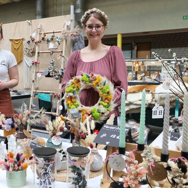 Die Ausstellerinnen Janina Fischer und Ann-Kathrin Hein an einem Tisch mit vielen Dekorationsartikeln.