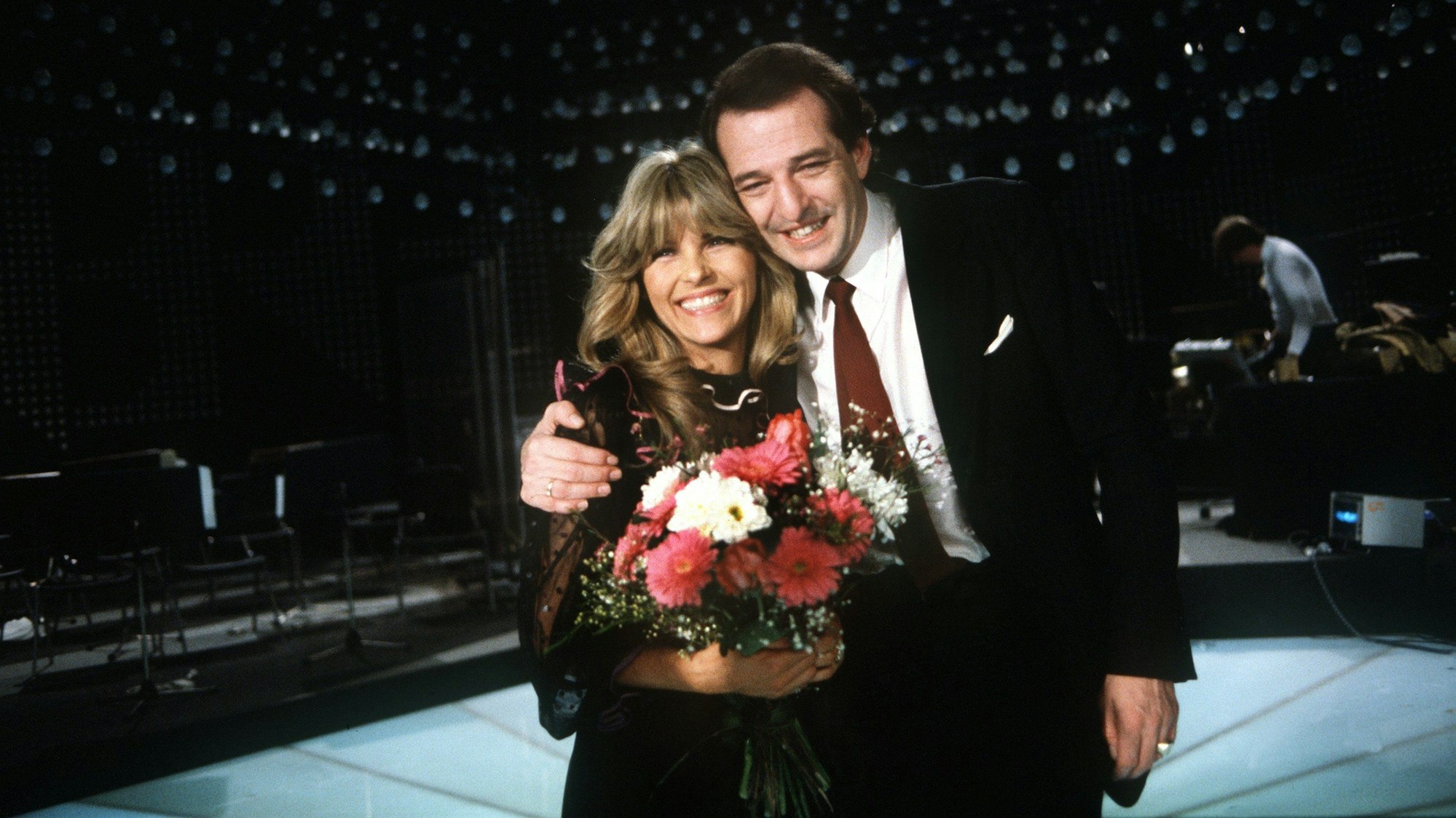 Der deutsche Schlagerkomponist Ralph Siegel freut sich mit Lena Valaitis über ihren Sieg bei der deutschen Vorentscheidung zum damaligen Grand Prix d'Eurovision de la Chanson 1981 mit Siegels Titel „Johnny Blue“. Sie hat einen Blumenstrauß in der Hand.