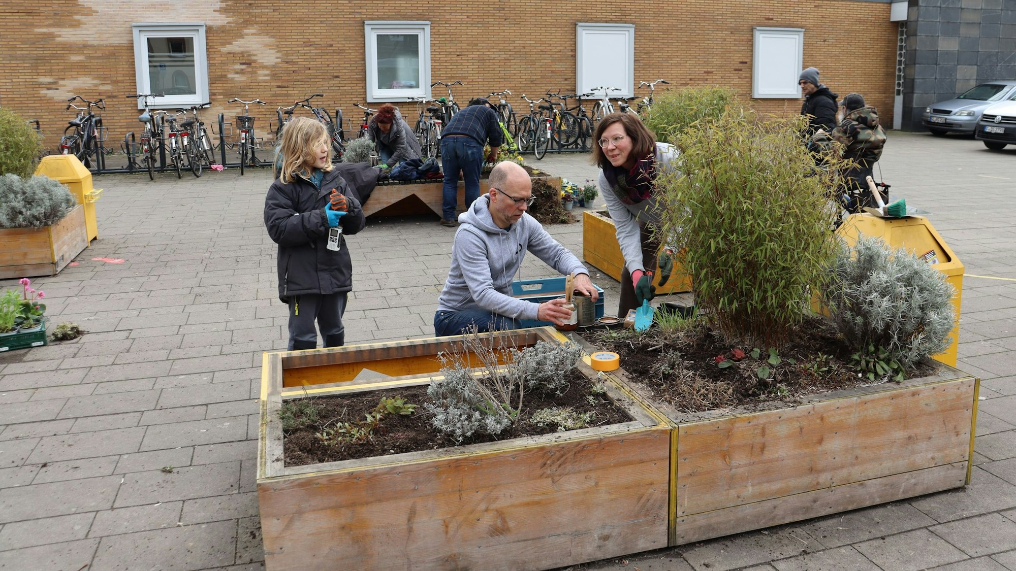 Matteo Langner, Stefan Winkelmann und Sonja Langner (v.l.) bepflanzen eines der Hochbeete. Foto: Uwe Schäfer