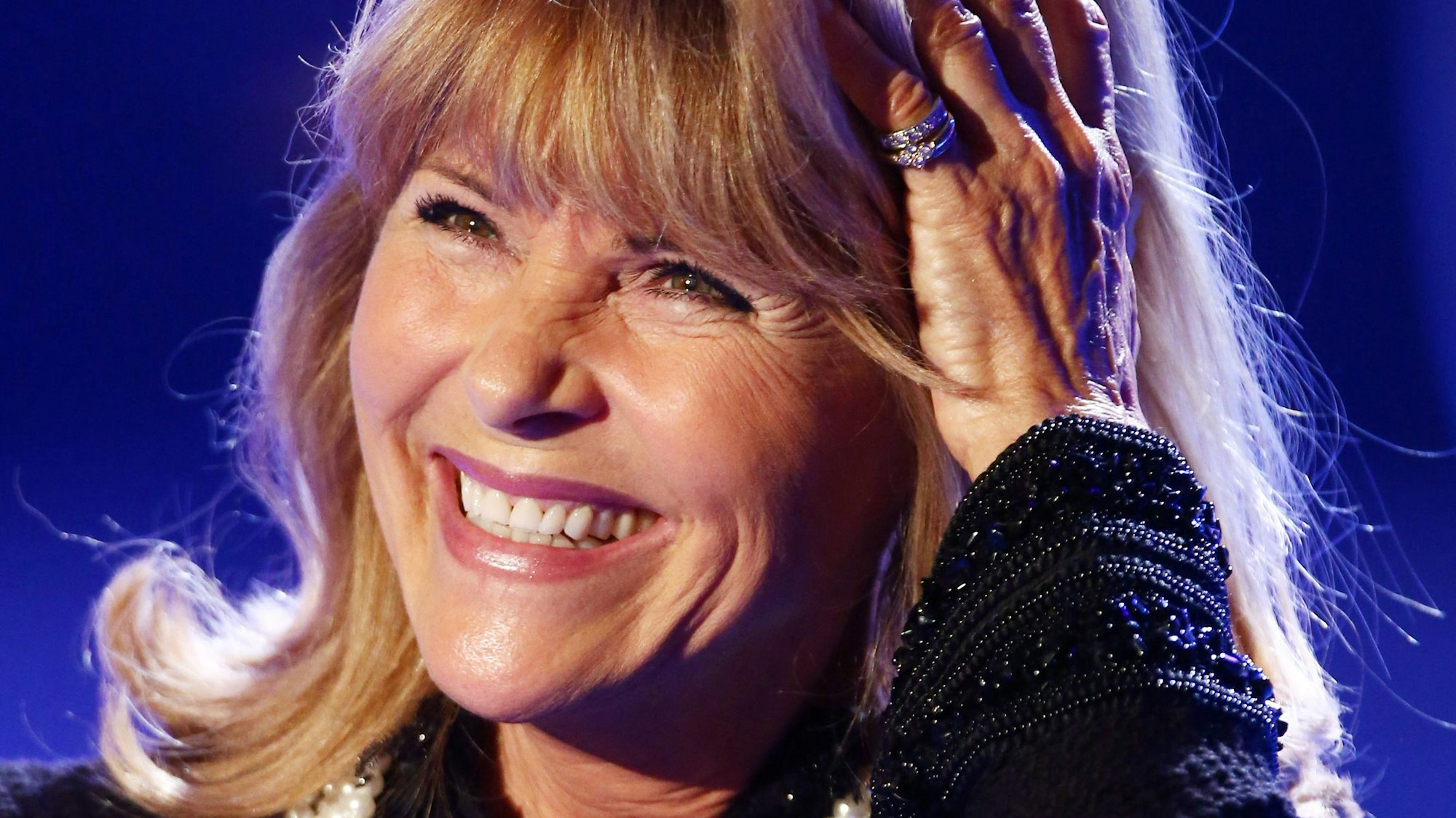 Lena Valaitis lacht bei einem Auftritt 2018 und fährt sich mit der Hand durch die Haare.