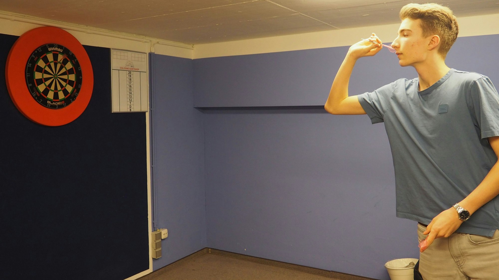 Alexander Steinmetz spielt Darts in seinem Trainingskeller.