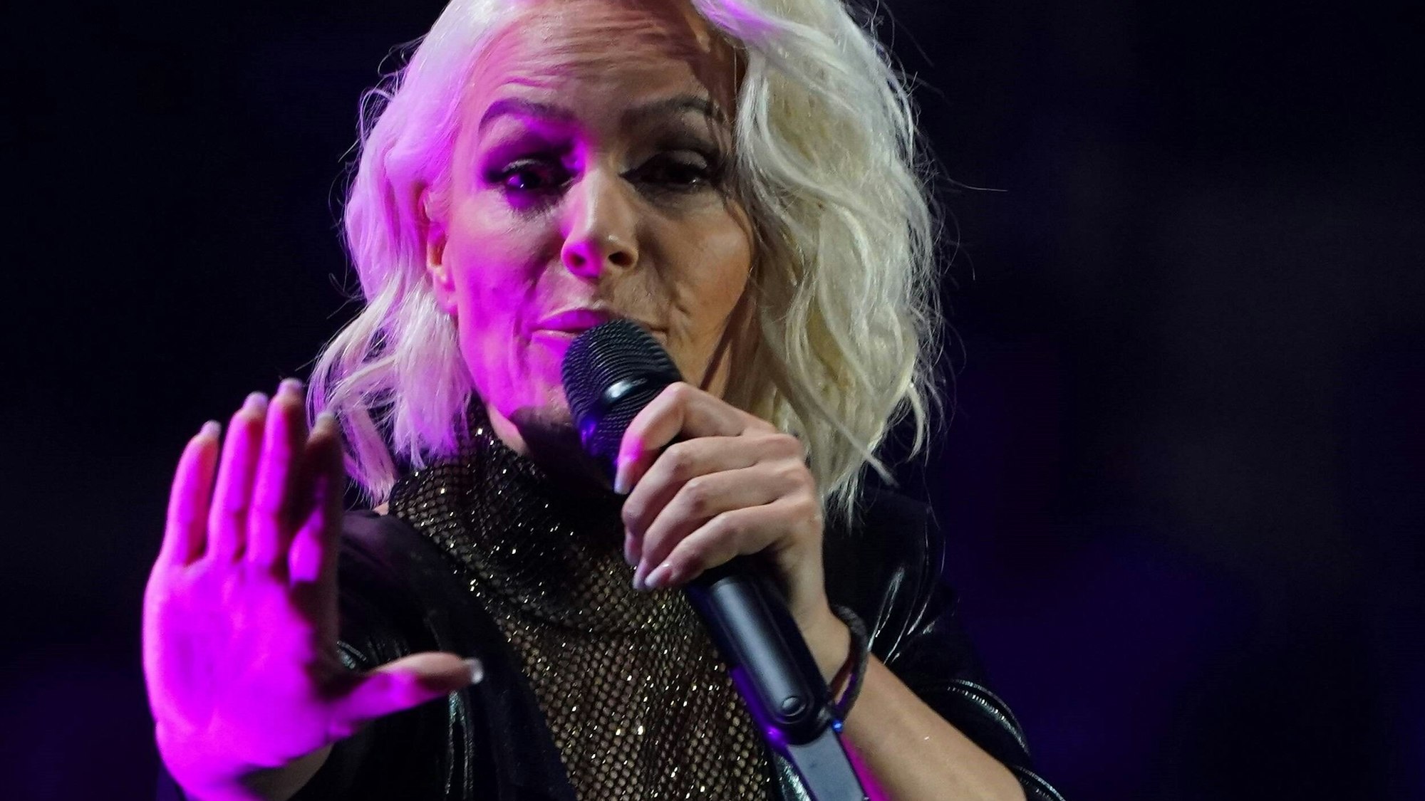 Michelle streckt die Hand bei einem Konzert aus.