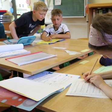 Eine Grundschülerin macht Aufgaben.