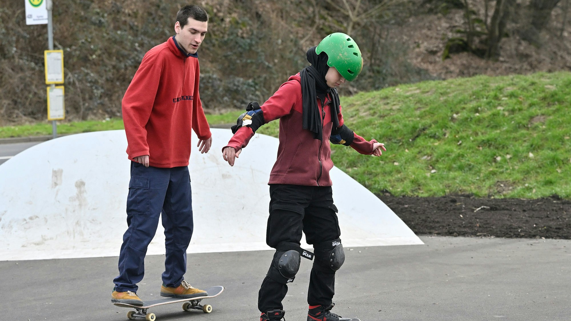 Zwei Jugendliche fahren auf ihren Skateboards.