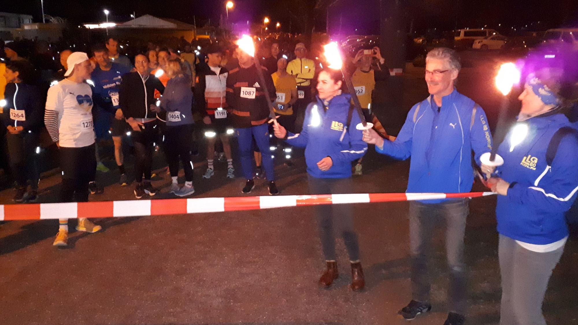 Absperrband als Startlinie, dahinter die Läufer und Helfer