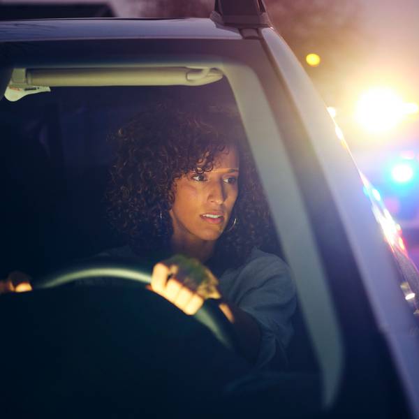 Frau im Auto wird bei einer Verkehrskontrolle gestoppt.