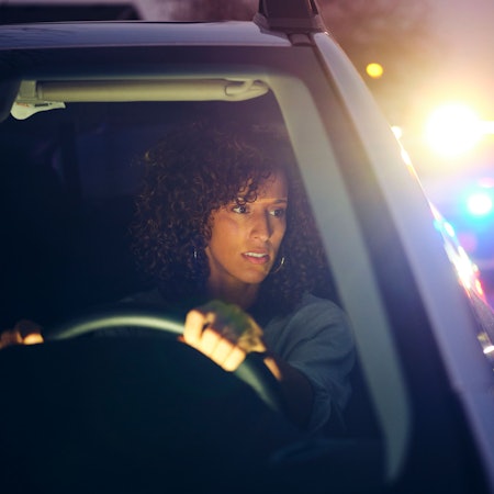 Frau im Auto wird bei einer Verkehrskontrolle gestoppt.