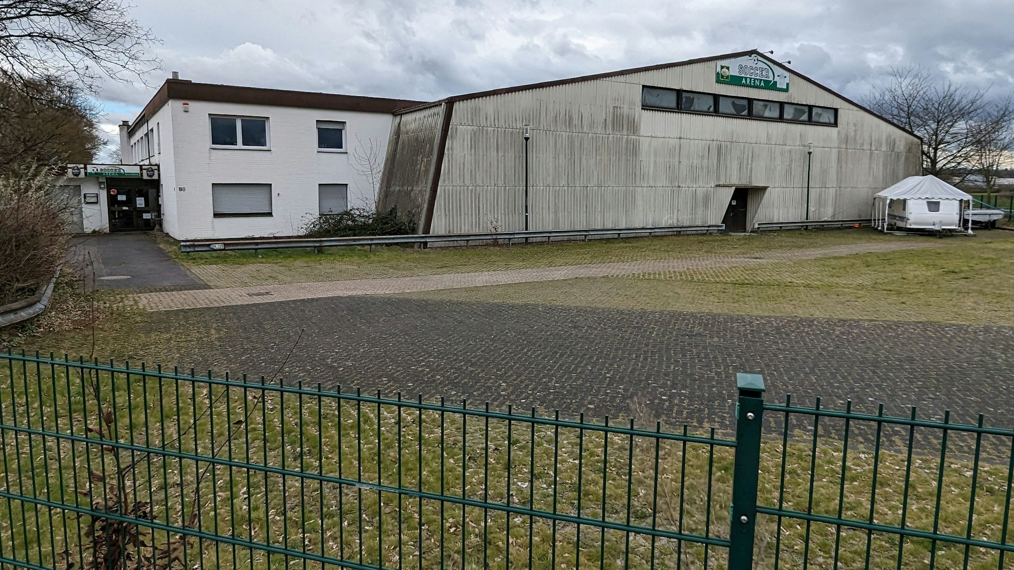 Blick auf die Soccerhalle. Im Vordergrund ist der leere Parkplatz.