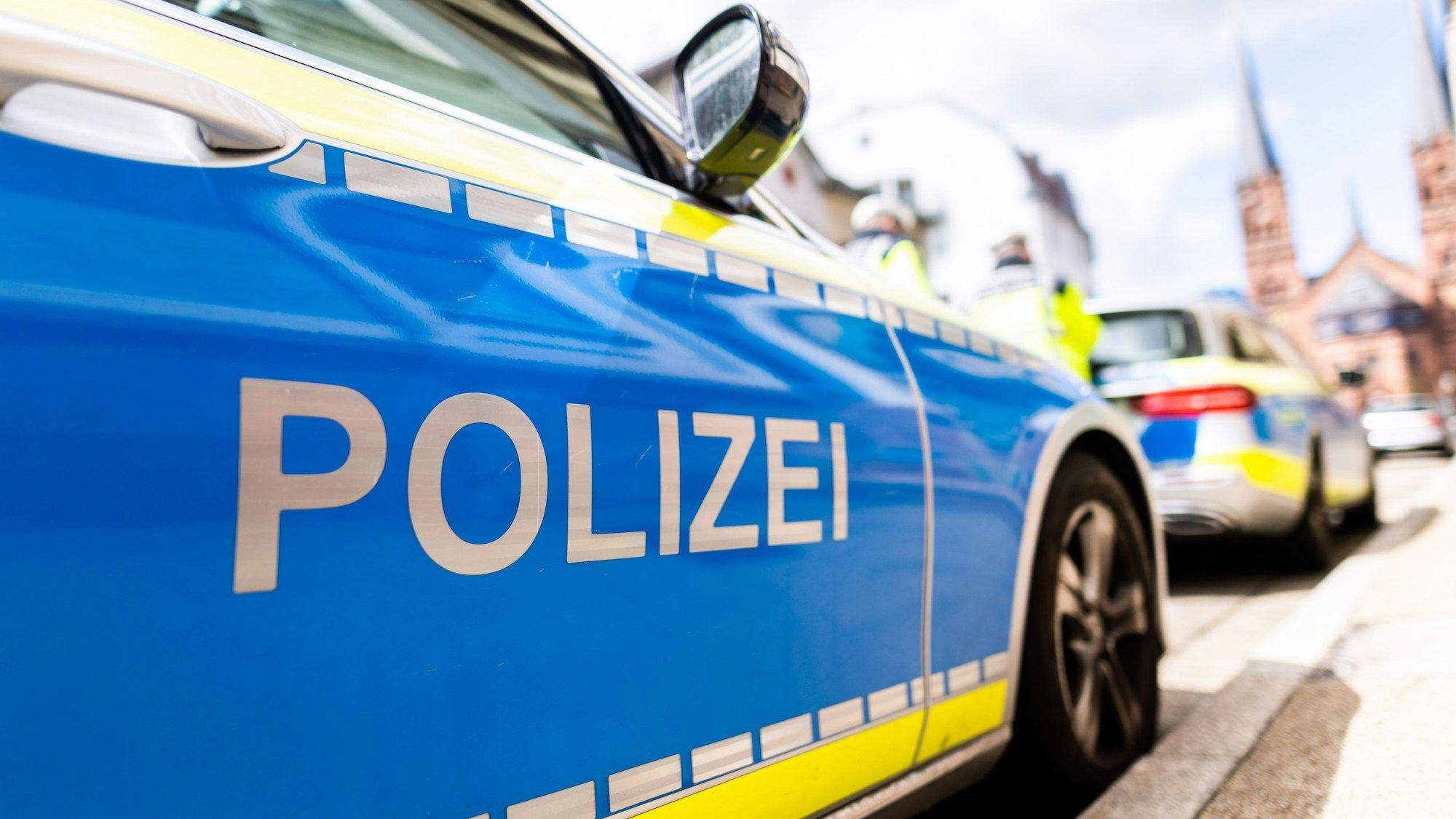 Zwei Einsatzfahrzeuge der Polizei stehen in Freiburg am Straßenrand. (Symbolbild)