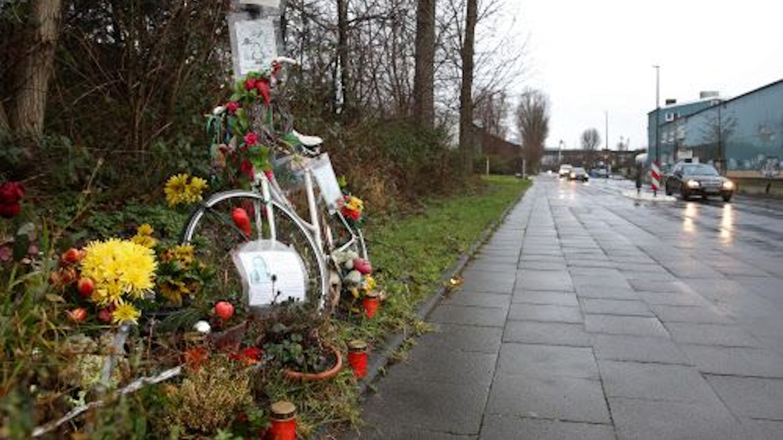 Ein weißes Fahrrad, Blumen und Kerzen am Rand des Radwegs entlang des Auenwegs in Köln-Mülheim erinnern an die verstorbene Miriam Scheidel