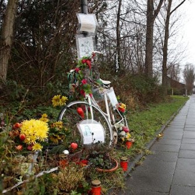 Ein weißes Fahrrad, Blumen und Kerzen am Rand des Radwegs entlang des Auenwegs in Köln-Mülheim erinnern an die verstorbene Miriam Scheidel