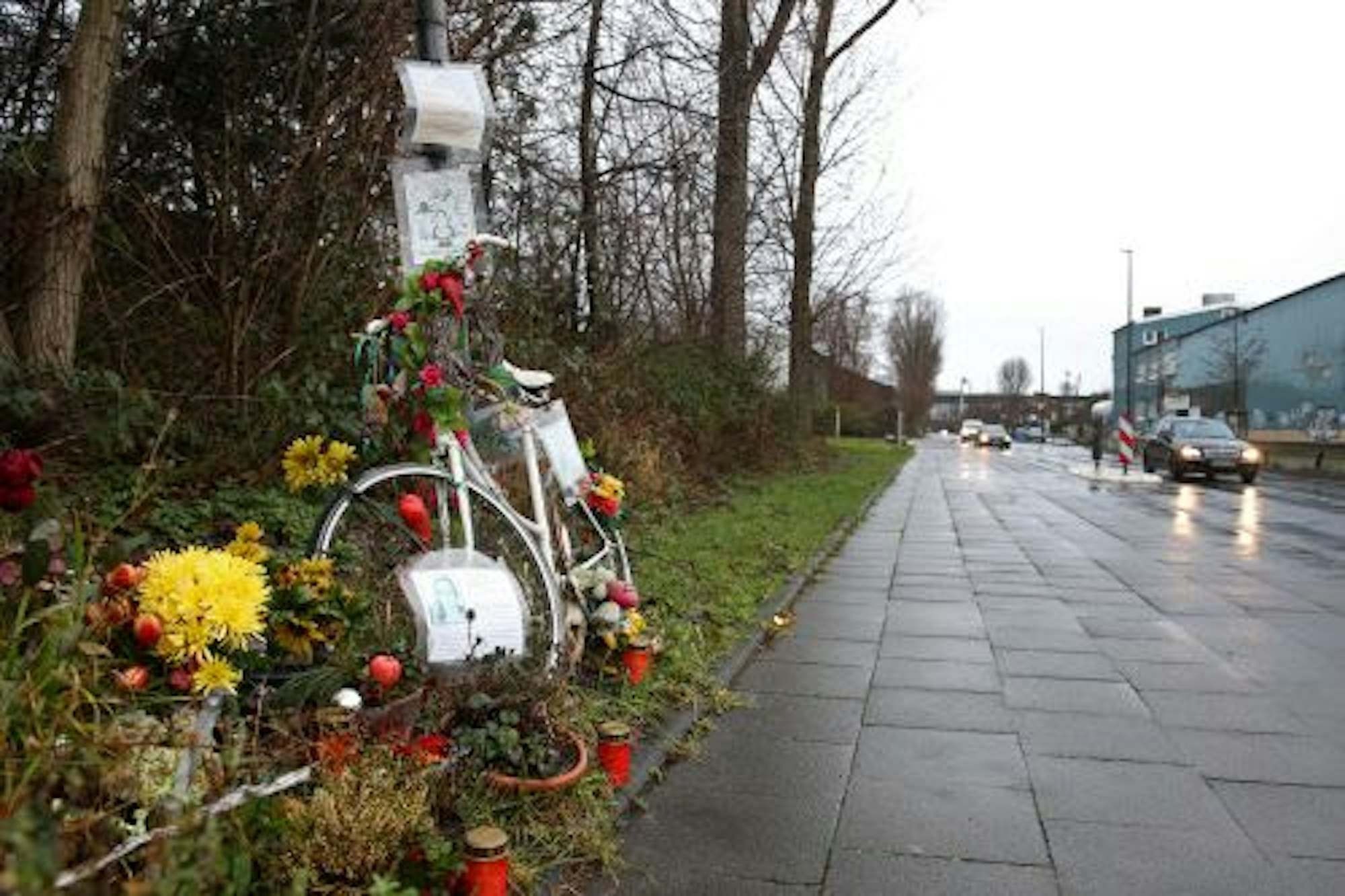 Ein weißes Fahrrad, Blumen und Kerzen am Rand des Radwegs entlang des Auenwegs in Köln-Mülheim erinnern an die verstorbene Miriam Scheidel