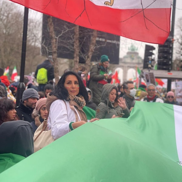 Mitra Nasiri-Sarvi bei einer Demonstration in Deutschland. Sie hält gemeinsam mit anderen Protestierenden eine Iranische Flagge in den Händen.