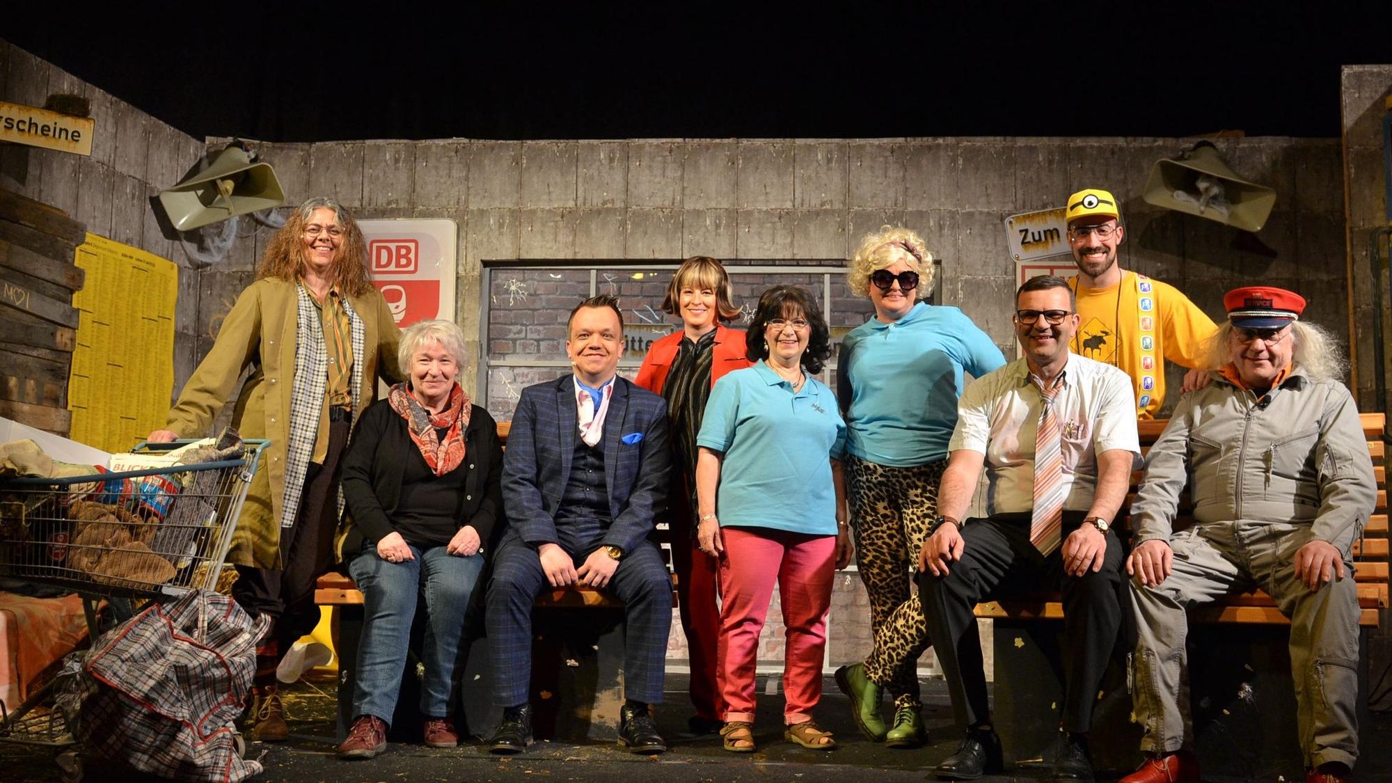 Die Schauspielerinnen und Schauspieler der Gruppe Lampenfieber stehen vor einer Bühnenkulisse.