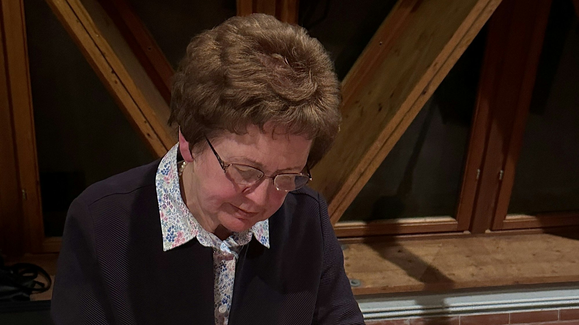 Schricke signiert an einem Tisch ein Buch.