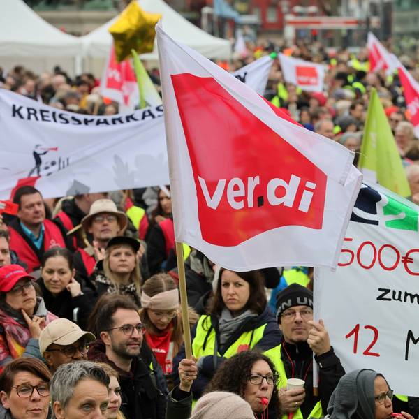 Streikende halten Schilder in die Luft.