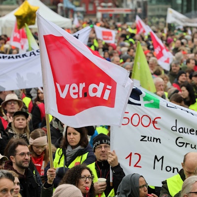 Streikende halten Schilder in die Luft.