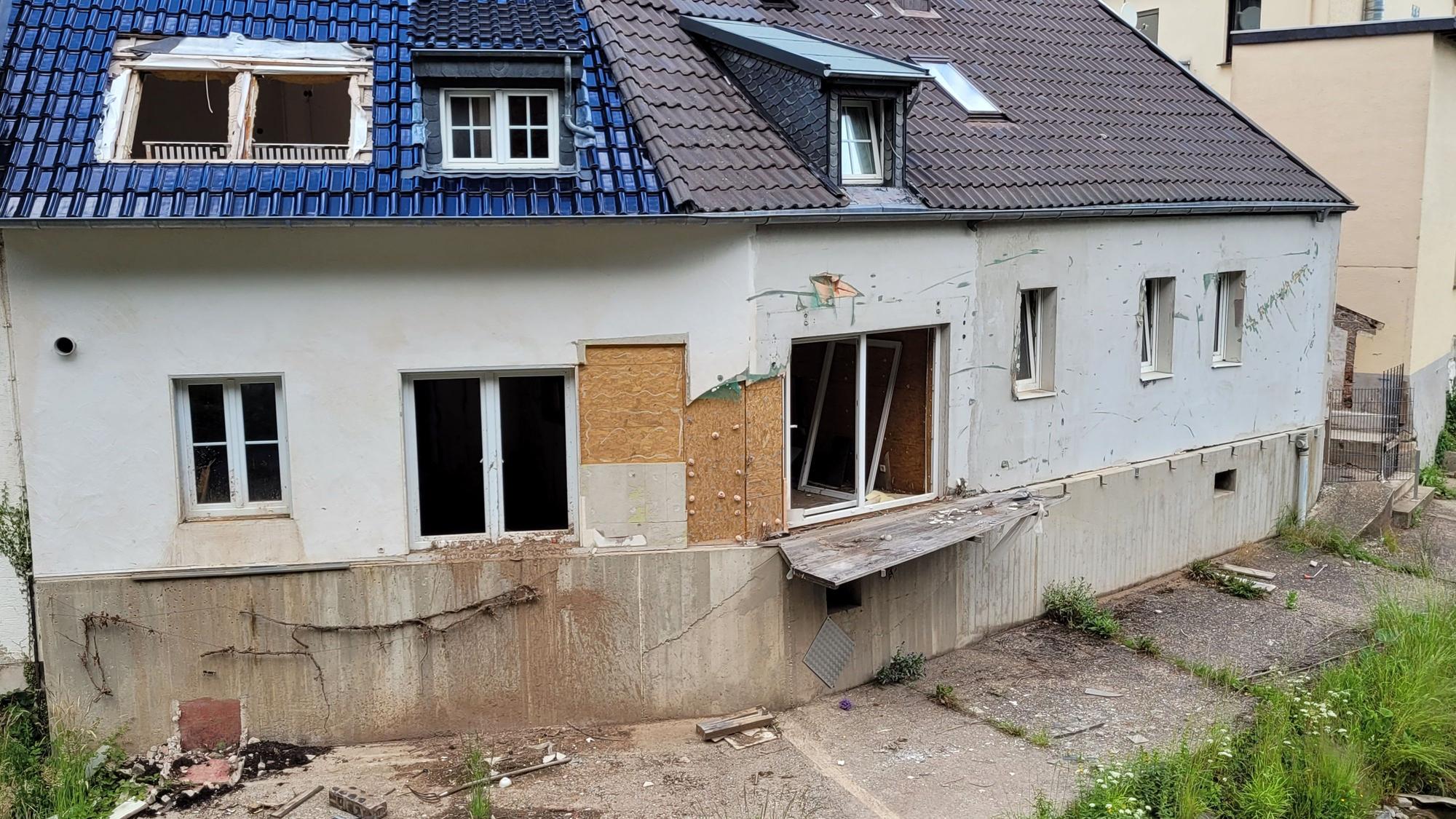 Das Bild zeigt ein Fluthaus mit kaputten Fenstern und Türen.