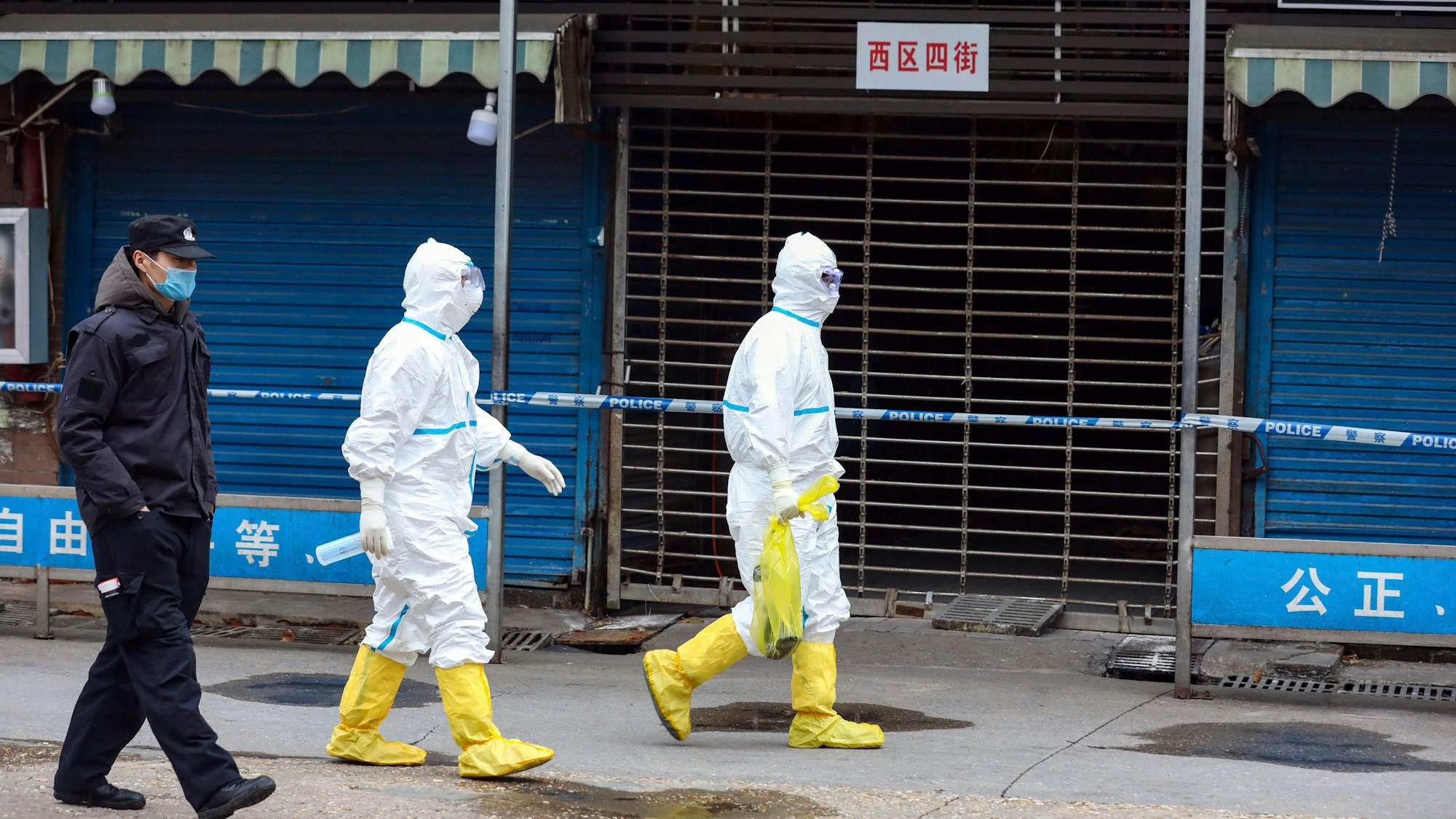 Wuhan: Arbeiter in Schutzkleidung tragen eine Tasche vom Huanan Seafood Market. Vorläufige Ergebnisse einer neuen genetischen Untersuchung stützen die Vermutung eines natürlichen Ursprungs von Sars-CoV-2.