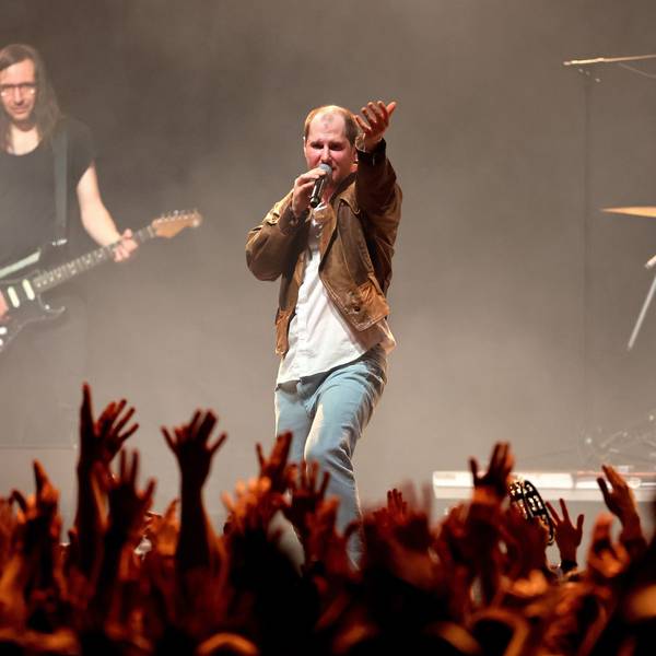 Die Band Wanda spielt am 20. März 2023 im Kölner Palladium. Sänger Marco Michael Wanda, wie immer mit derselben speckigen Lederjacke bekleidet, dirigiert die Menge, die die Hände erhoben hat.
