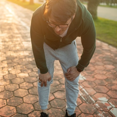 Mann in Joggingkleidung sieht erschöpft aus.