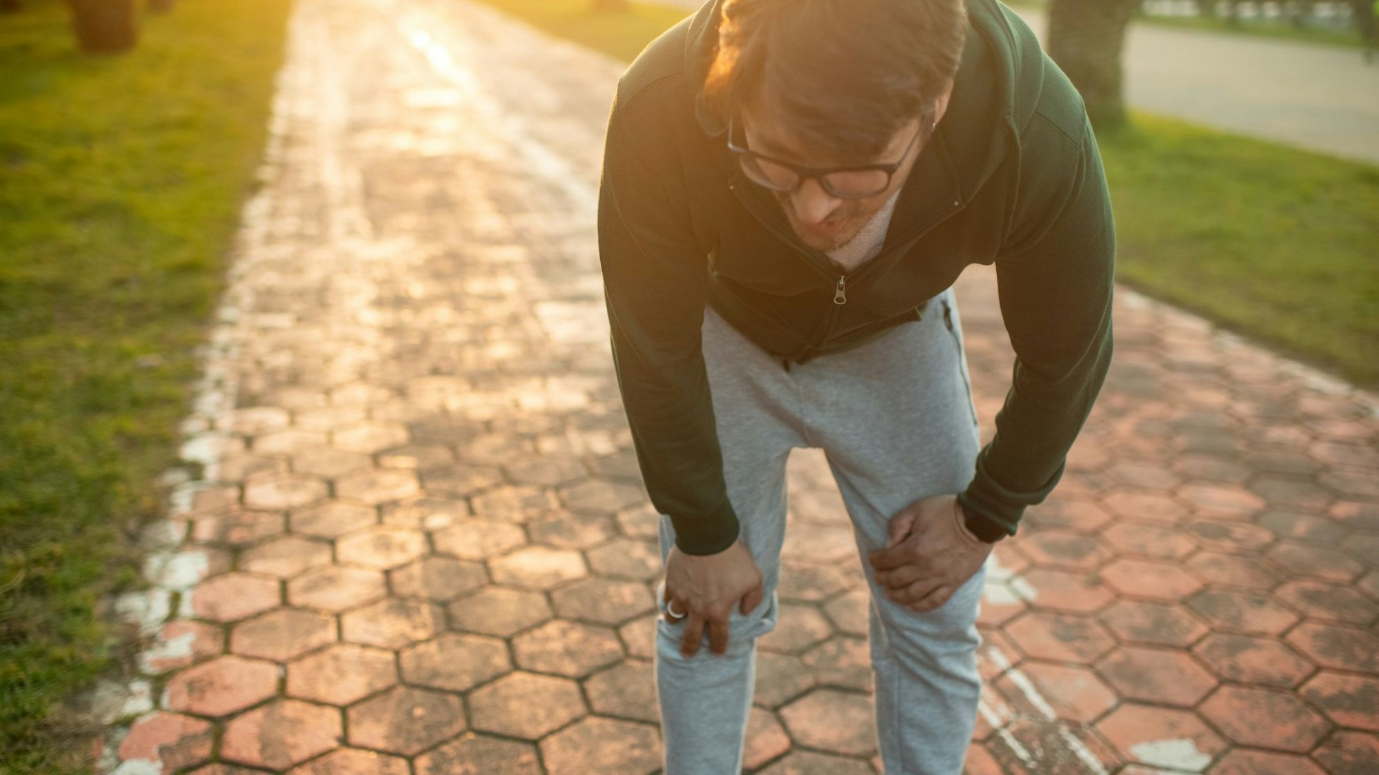 Mann in Joggingkleidung sieht erschöpft aus.