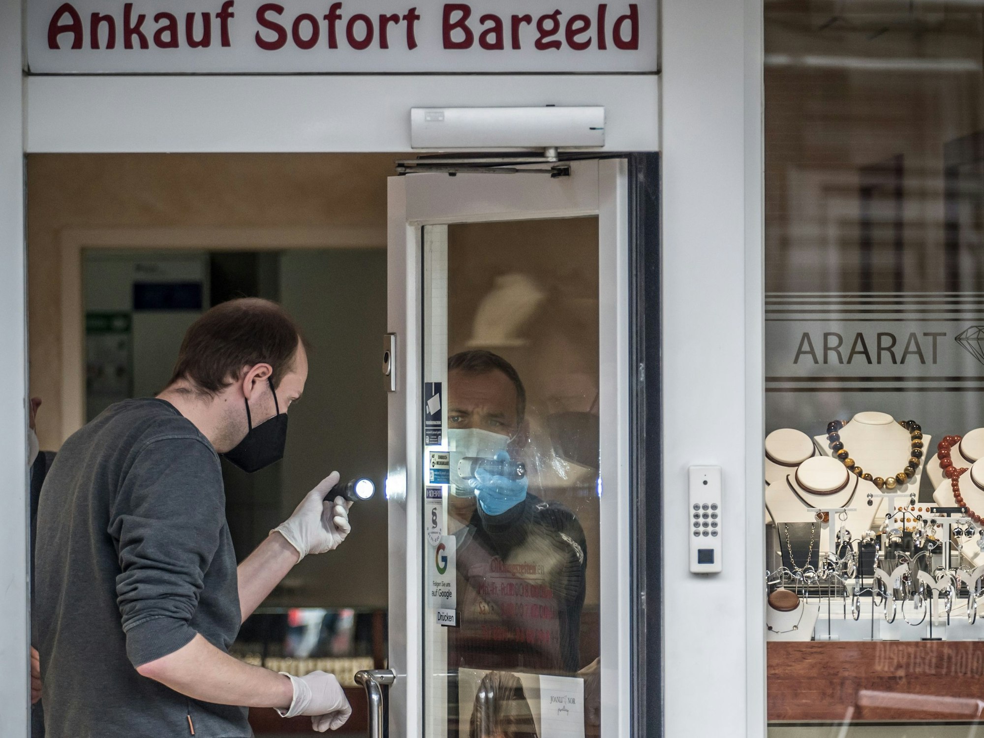 Polizist mit Taschenlampe an dem Geschäft