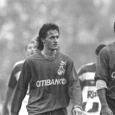 Zwei Fußball-Spieler des 1. FC Köln verlassen mit enttäuschtem Blick das Spielfeld. Das Foto ist in schwarz-weiß.