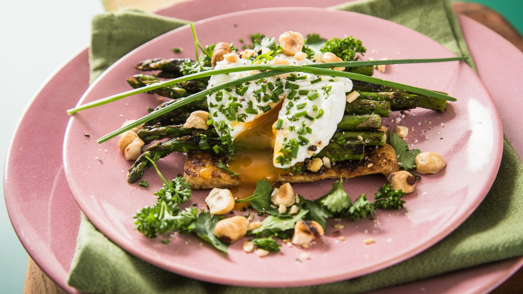 pochiertes Ei auf grünem Spargel garniert mit Schnittlauch