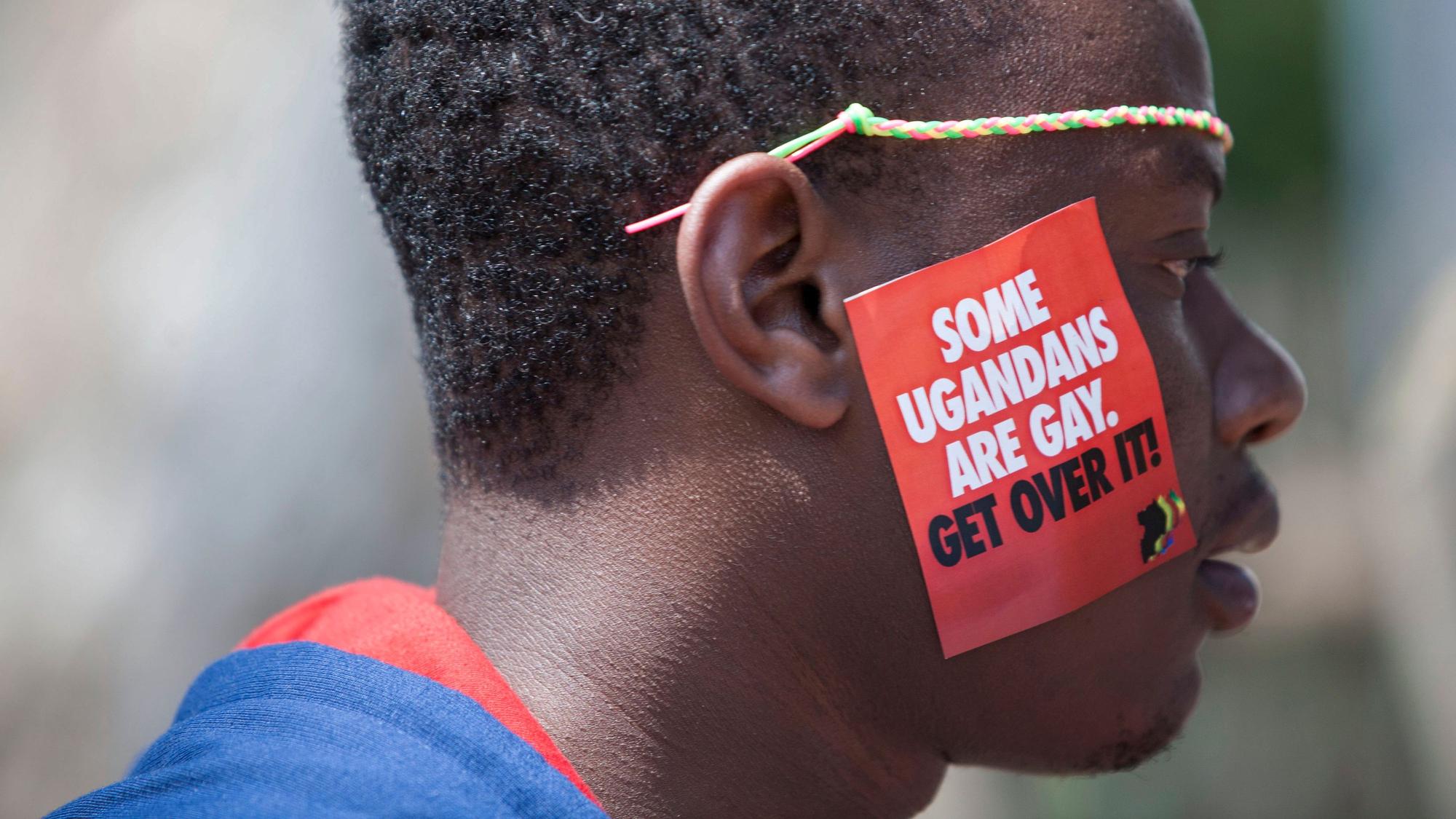 dpatopbilder - ARCHIV - 08.08.2014, Uganda, Entebbe: Ein ugandischer Mann trägt einen Aufkleber mit der Aufschrift "Some Ugandans Are Gay. Get Over It" ("Einige Ugander sind schwul. Finde dich damit ab") während der LGBT-Pride-Feierlichkeiten auf seiner Wange. Die ugandische Regierung hat ein Gesetz verabschiedet, das Gefängnisstrafen von bis zu zehn Jahren für Straftaten im Zusammenhang mit gleichgeschlechtlichen Beziehungen vorsieht und damit auf die Stimmung in der Bevölkerung reagiert, aber auch den Druck auf die LGBTQ-Gemeinschaft des ostafrikanischen Landes erhöht. Foto: Rebecca Vassie/AP/dpa +++ dpa-Bildfunk +++