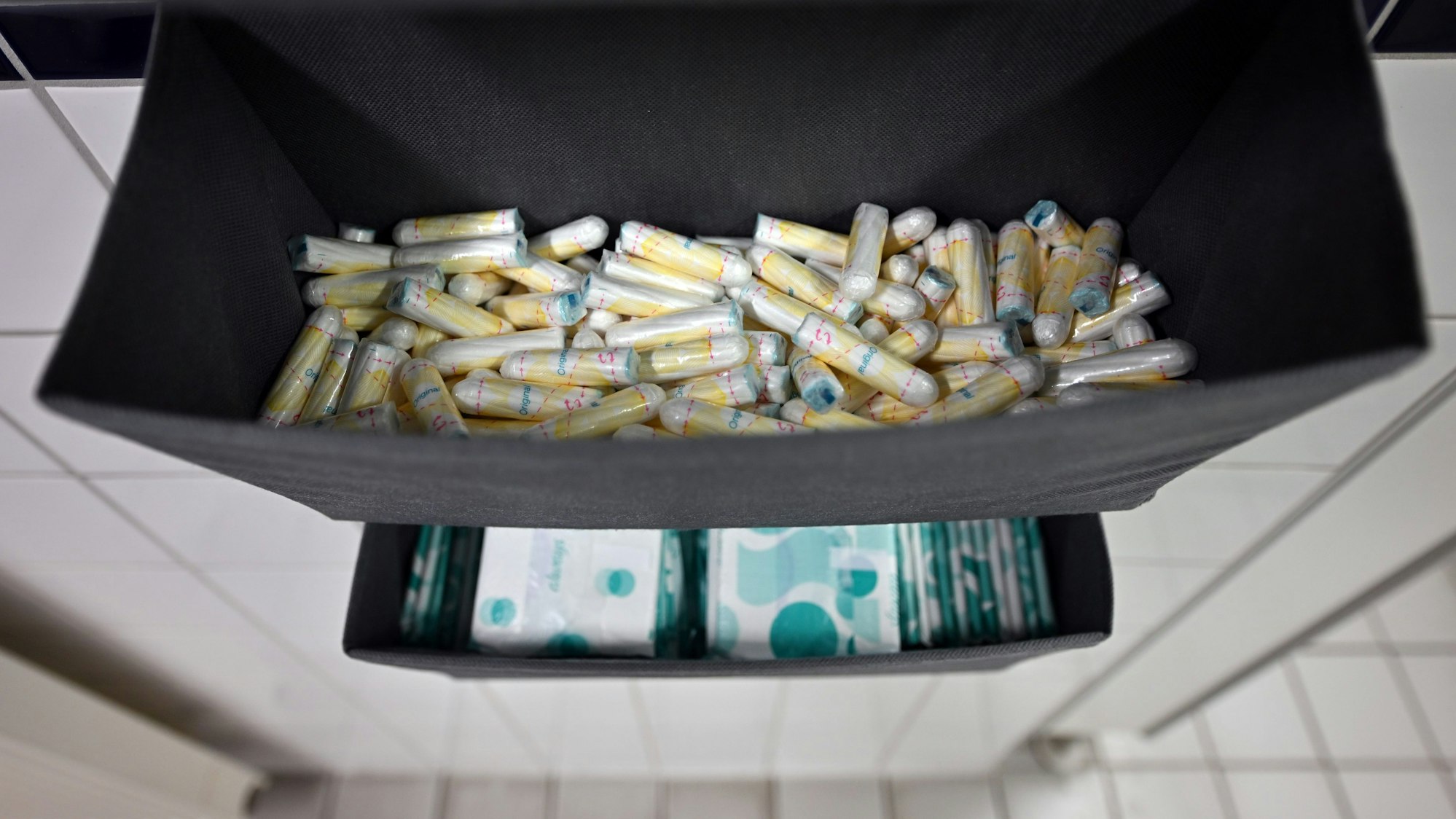 Damenbinden und Tampons liegen in einer Toilette aus. (Symbolbild)