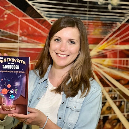 Die Autorin hält ihr neues Buch in der Hand.